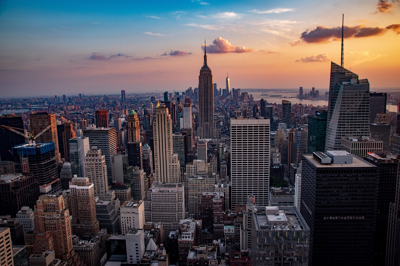 New York City skyline at night, showcasing bright lights, iconic skyscrapers, and bustling streets, representing the city's vibrant entertainment and nightlife scene